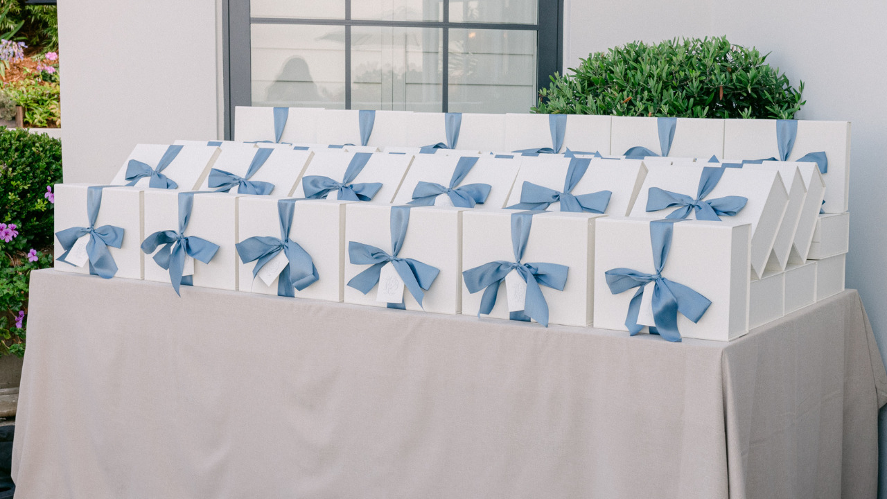 image of white wedding welcome bags with blue ribbon sitting on table