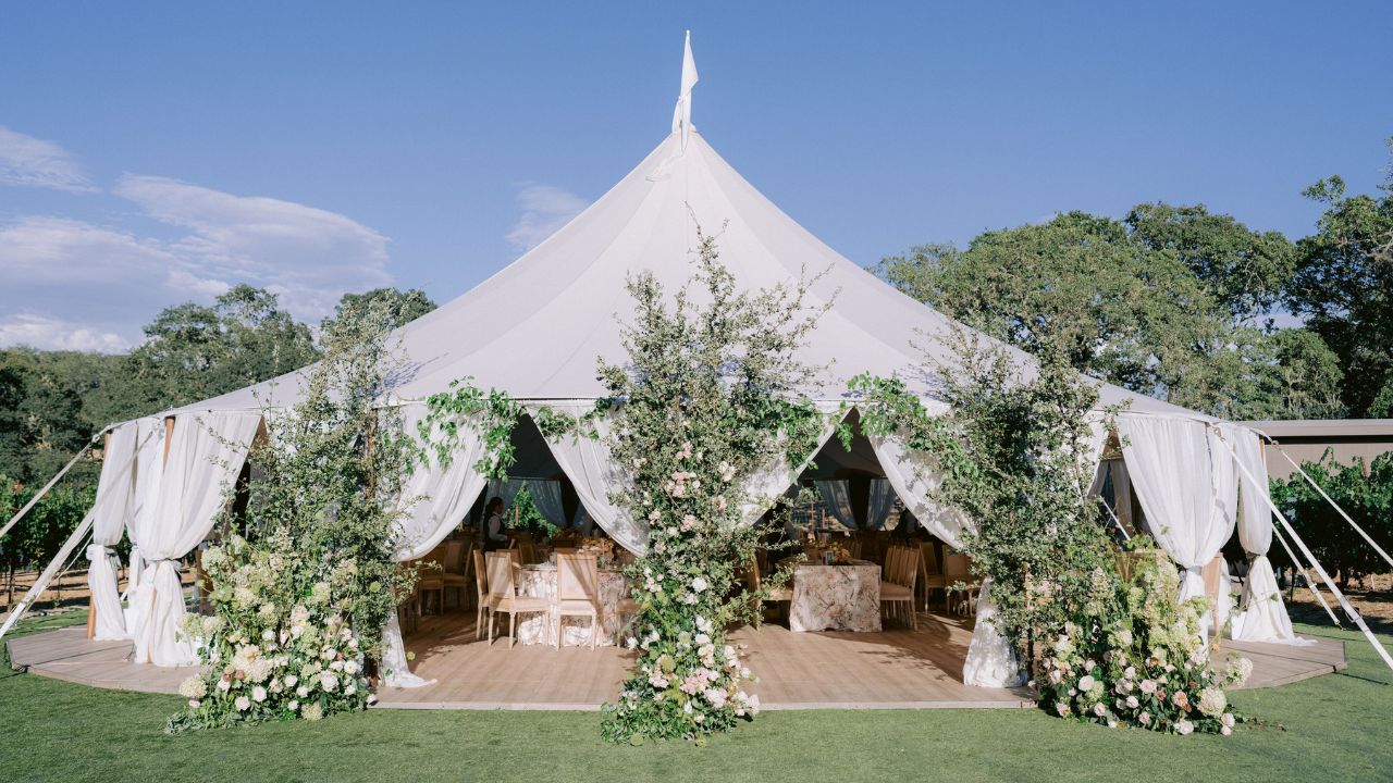 photo of white wedding reception tent with floral accents